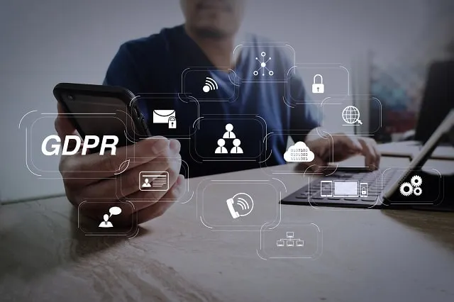 GDPR- und Datenschutzsymbole überlagern das Bild einer Person, die ein Smartphone und einen Laptop benutzt 