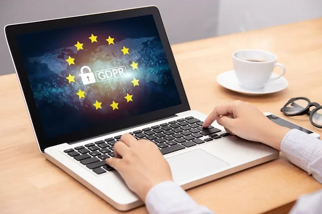 Person typing on laptop with GDPR logo overlaid on world map image