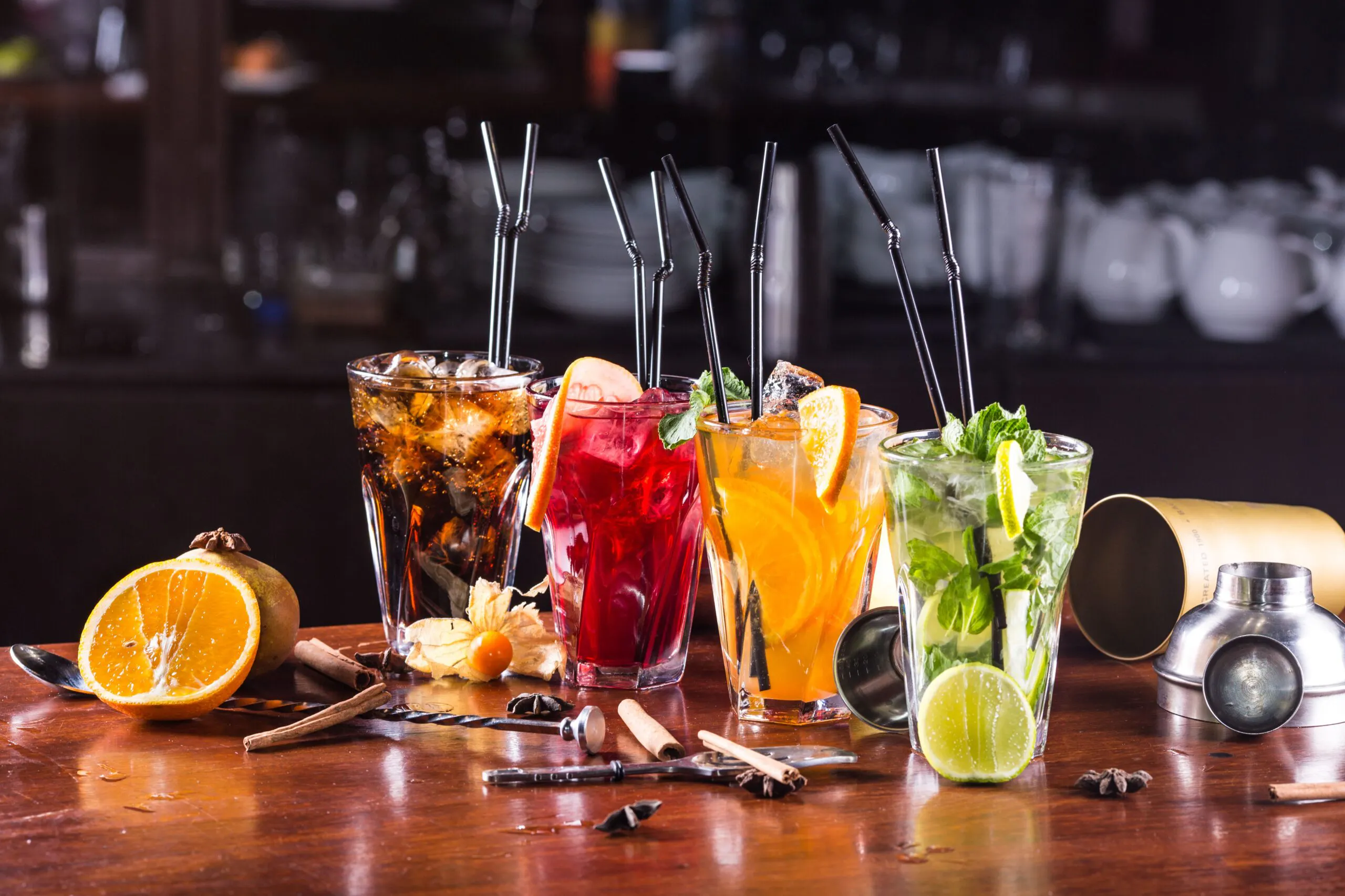 Row of colorful cocktails with straws
