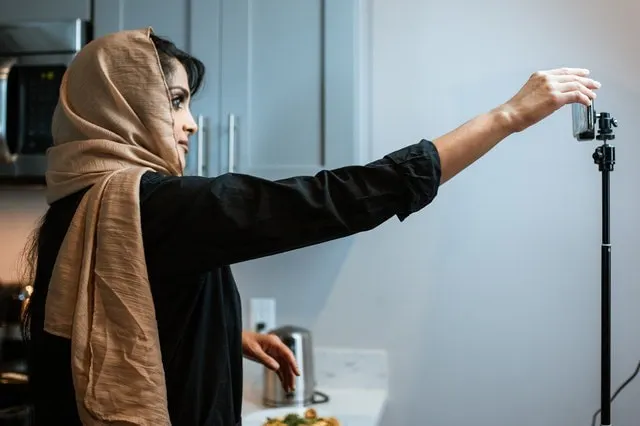 Frau stellt Kamera ein, um ein Erklärvideo aufzunehmen