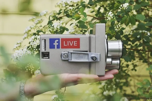 Videokamera mit Facebook-Logo und Live-Bild an der Seite/Facebook Live-Konzept