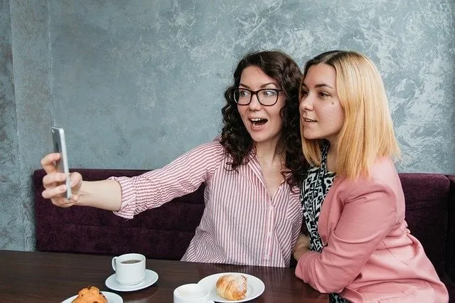 Amigos compartiendo en Snapchat en una cafetería 