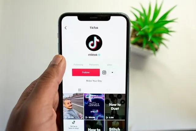 Hand holding a mobile device with the TikTok app on screen