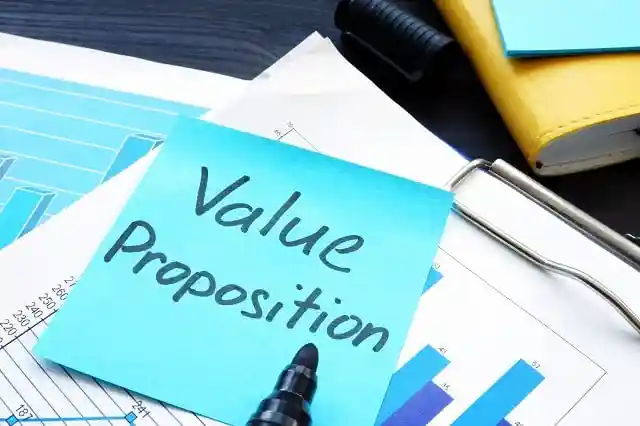 Sticky note with "Value Proposition" on a clipboard with papers