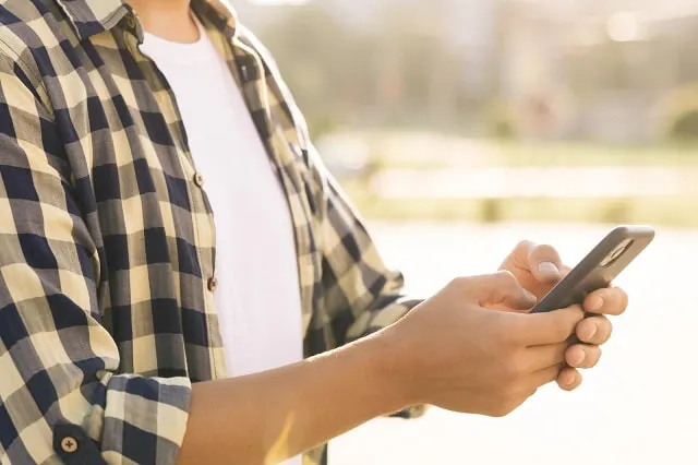 Person, die ein Mobiltelefon benutzt und jemanden auf Instagram stummschaltet