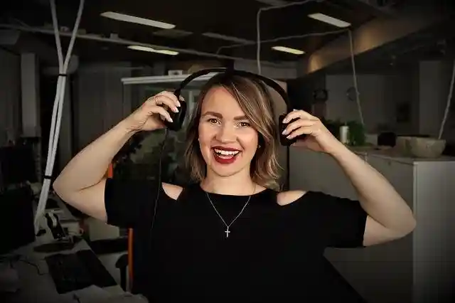 Podcast host putting headphones on in a studio