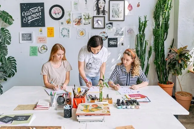 Drei Frauen, die ein kleines Geschäft betreiben und Kunsthandwerk verkaufen oder Kunstunterricht geben 