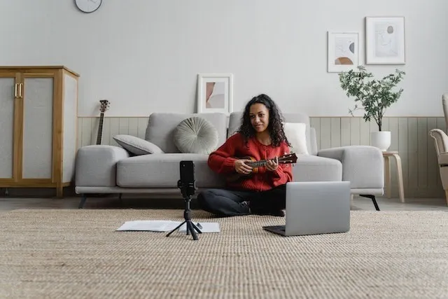 Frau nimmt sich selbst beim Spielen eines Instruments für ein Instagram-Reel auf